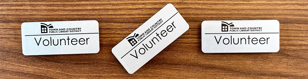 Three volunteer badges on a desk