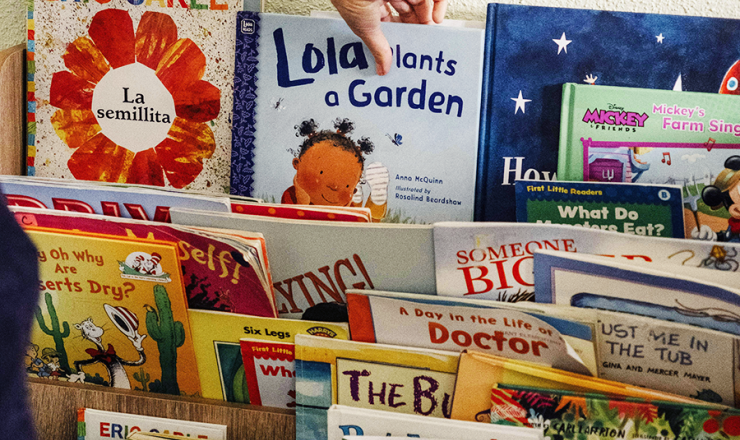 someone selecting a book from a display of children's books